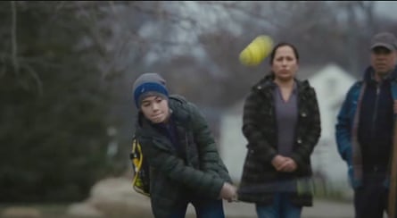 a child goes to hit the ball after Romn has offered him a million dollars if he can hit a home run and his parents look on axiously