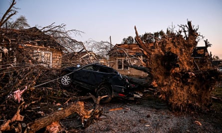 The remains of a house and cars entangled in tree limbs in Rolling Fork