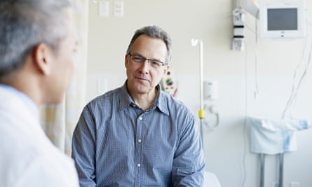 Doctor talking to mature male patient in hospital room