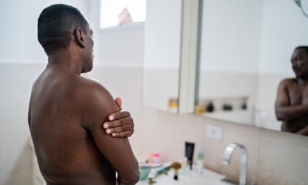 Senior man applying moisture on body at home