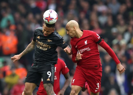 Gabriel Jesus heads the ball with Fabinho close by.